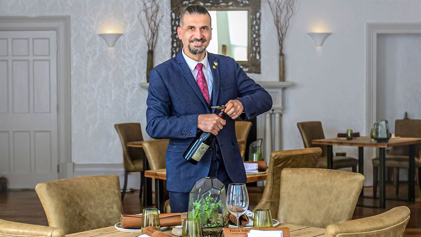 Wine director Michal Dumny opening a bottle of wine